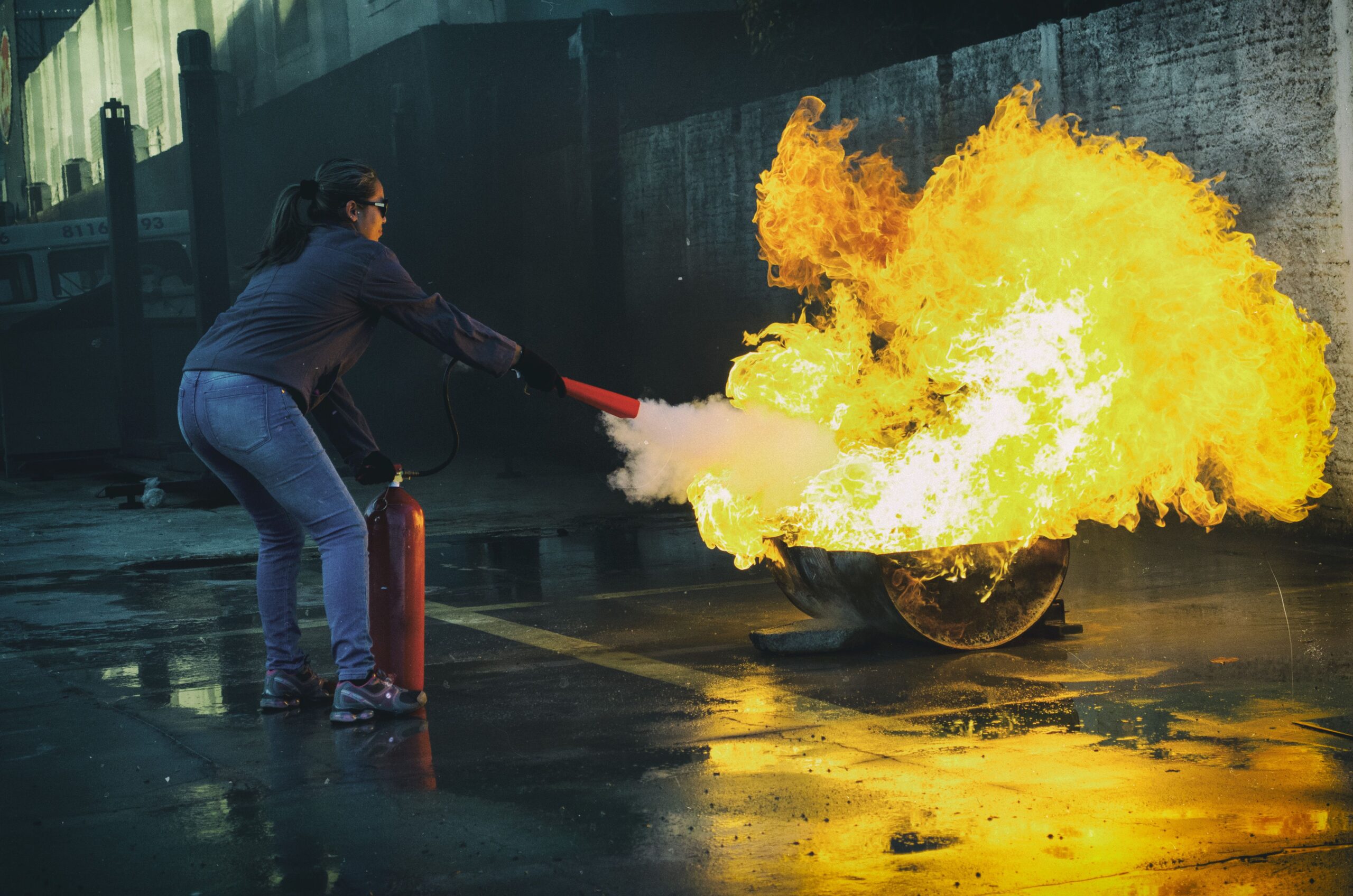 Brandschutzhelfer-Anzahl im Unternehmen: Mitarbeiter bei der praktischen Löschübung mit Feuerlöscher